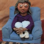 A claymation child in a chair looking surprised